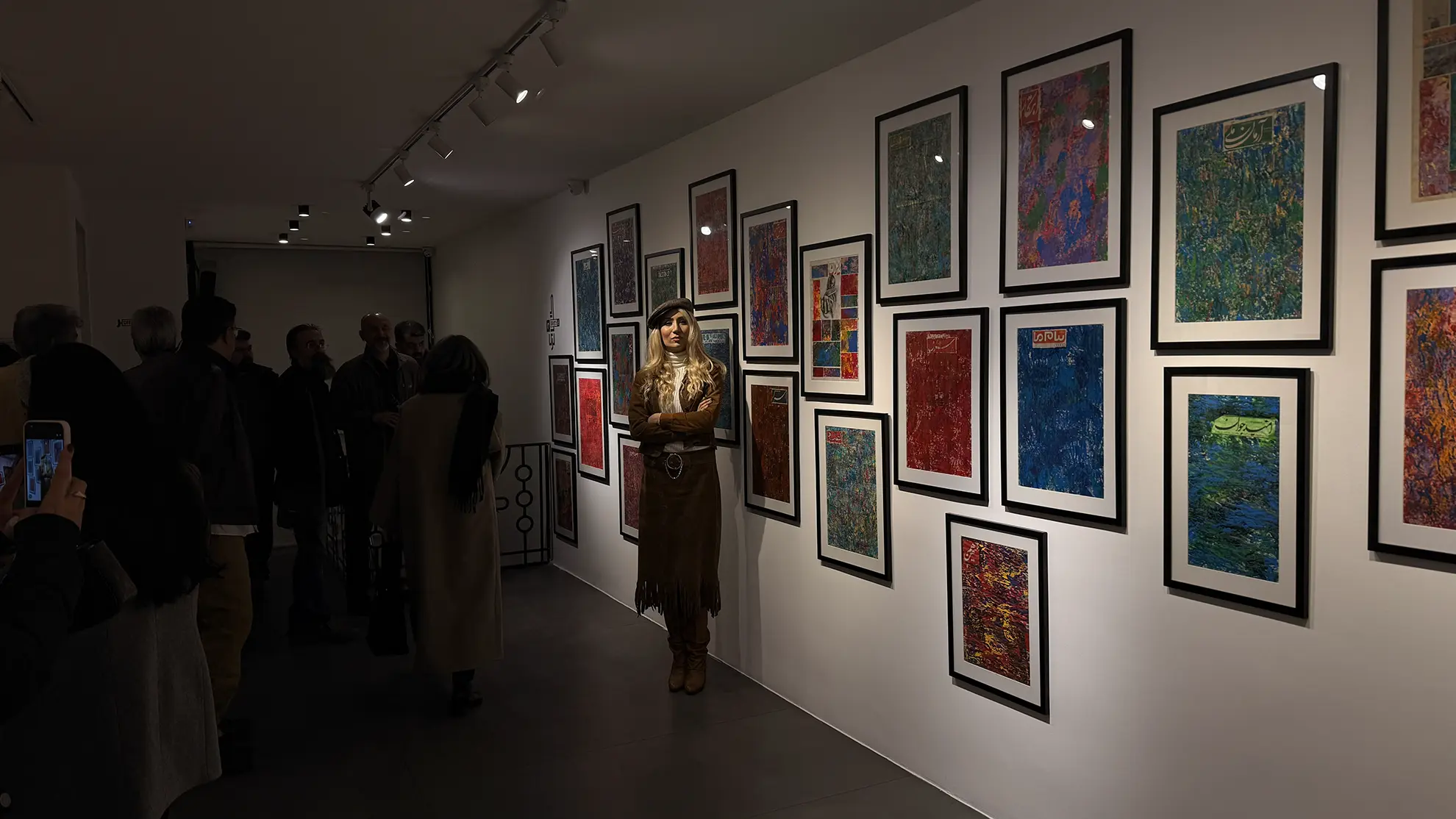 Exhibition visitors viewing a wall of curated works at Matin Curatorial House